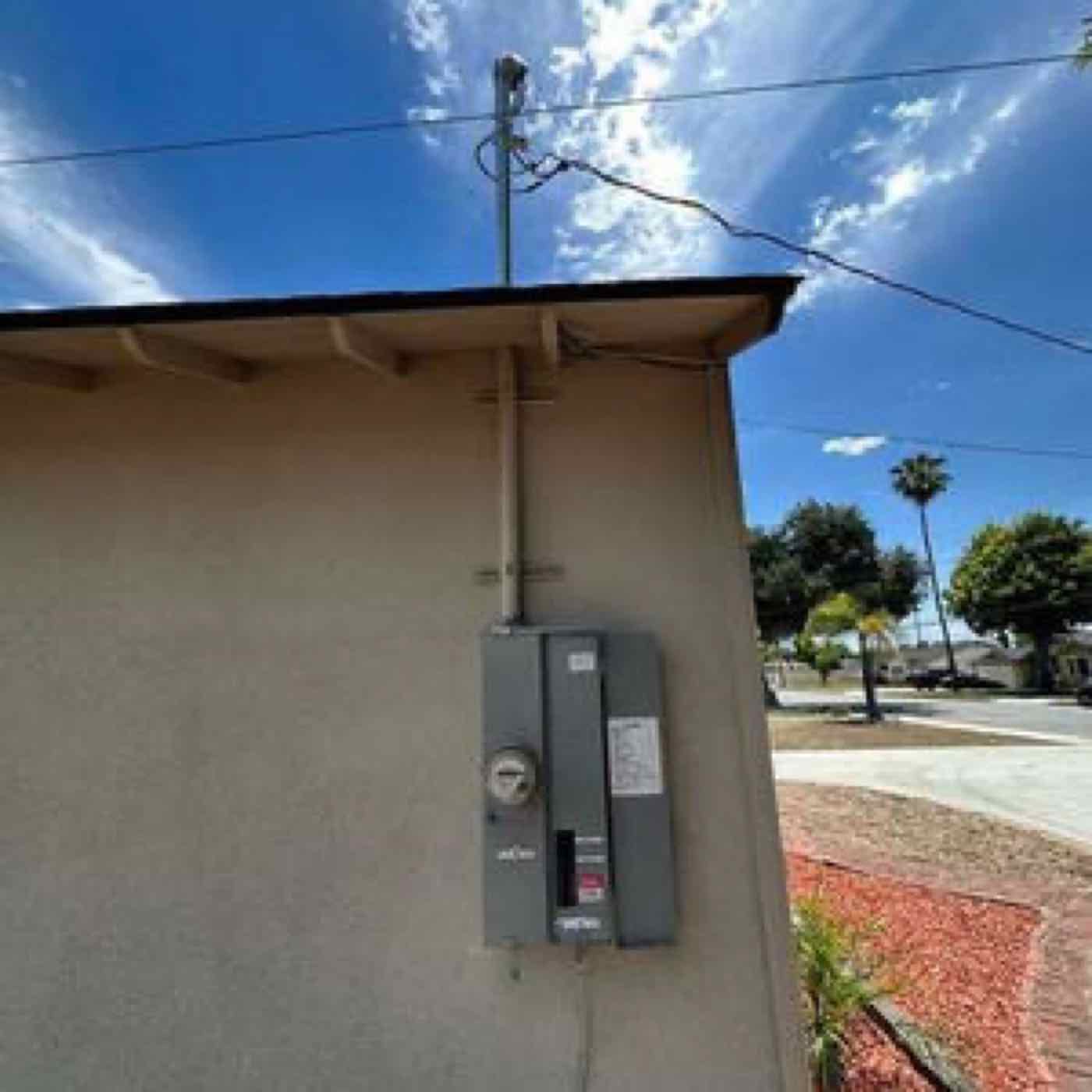An electric meter on the side of a house.